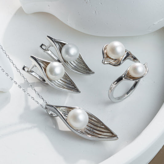 Silver jewelry set with pearls on a white surface
