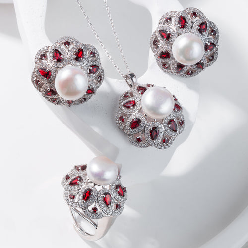 Jewelry set with pearls and red gemstones on a white background