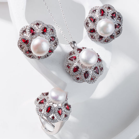 Jewelry set with pearls and red gemstones on a white background