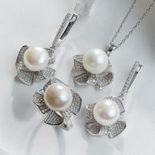 Qalereya görüntüsünə şəkil yükləyin, Pearl necklace and earrings set on a white background
