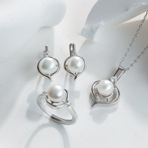 Pearl jewelry set including earrings and a necklace on a white background