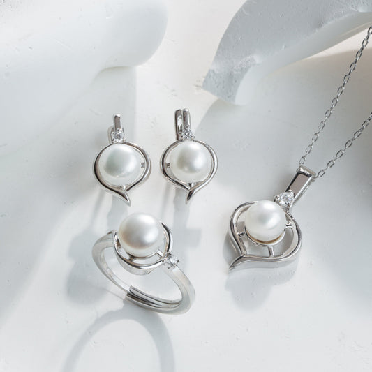 Pearl jewelry set including earrings and a necklace on a white background